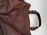 a brown bag sitting on a table next to a cell phone