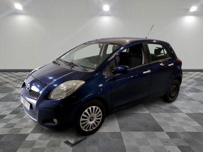 la photo d'une petite voiture bleue garée sur un sol en damier