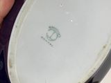 someone is holding a black and white plate with a red nail