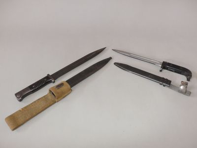 two knives and a knife holder on a white surface