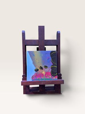 un chevalet miniature sur lequel est posé un tableau