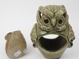 a small vase with a face on it next to a small vase with a face on it