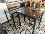 a glass table and chairs in a restaurant setting