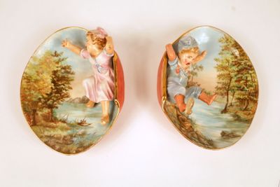 two plates with angels on them sitting next to each other