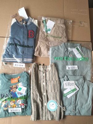 a lot of clothes that are sitting on a cardboard box