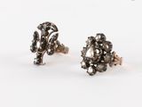 une paire de boucles d'oreilles en diamant noir et blanc sur fond blanc