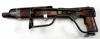 rifle on a white surface with a black handle and a wooden handle