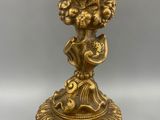 brass statue of a bird on a pedestal with flowers and leaves