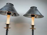 pair of metal lamps with candles on each of them on a table