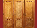 une armoire en bois à trois portes et deux tiroirs