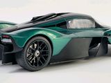 the green and black sports car is on a white surface