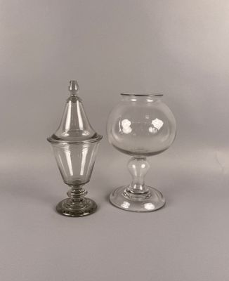 deux vases en verre transparent avec couvercle, posés sur une surface blanche