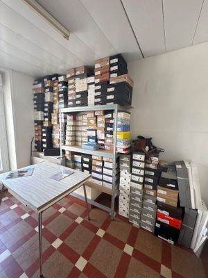 a room with a table and a lot of boxes on the shelves