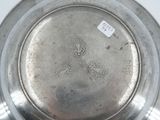 a silver plate that has a small sticker on it