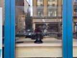 a statue of a man sitting on a table in a window