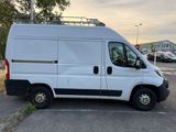 a white van parked in a parking lot with trees in the background