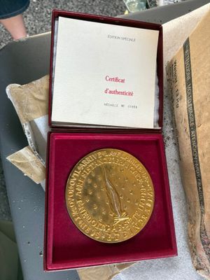 une image représentant une médaille d'or dans un coffret rouge posé sur une table