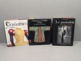 trois livres posés sur une table blanche, avec une photo en noir et blanc représentant un homme en costume et une femme en robe jaune