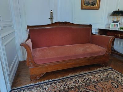 a red couch in a room with a rug on the floor