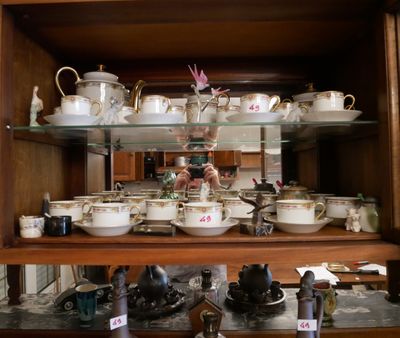 de nombreuses tasses et soucoupes sur les étagères de ce vaisselier