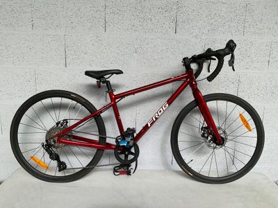 un vélo rouge appuyé contre un mur blanc