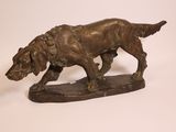 bronze statue of a dog on a wooden base on a white background
