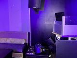 un lit et une télévision dans une pièce baignée d'une lumière violette