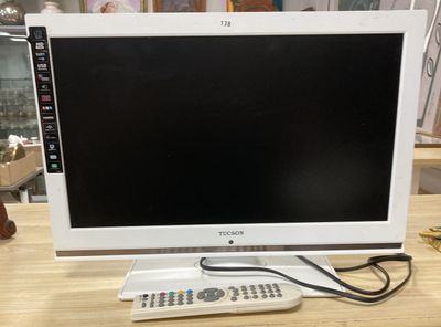 une télévision posée sur une table, avec une télécommande