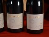 three bottles of wine sitting on a red cloth