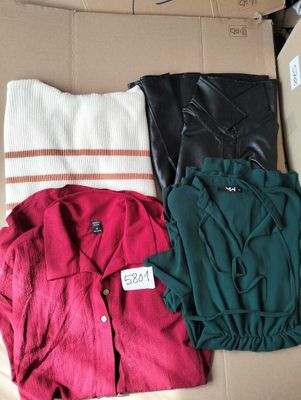 three pairs of shirts in a box on a couch