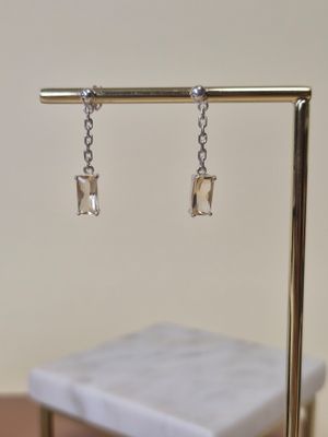 une paire de boucles d'oreilles posées sur un présentoir