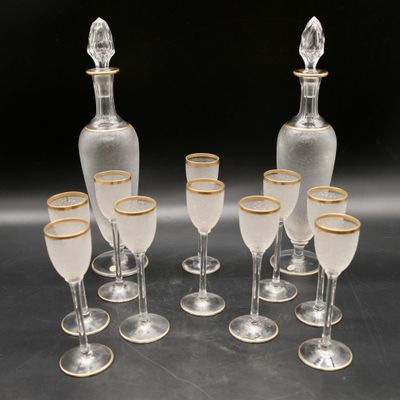 six verres à vin transparents et une carafe aux bords dorés