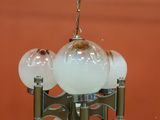 a chandelier with five glass globes hanging from the ceiling