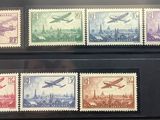 three stamps of different colors are on display in a glass case