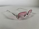 pink sunglasses on a white surface with a chain around them