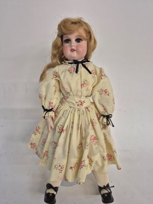 an image of a doll with blonde hair wearing a yellow dress and black shoes