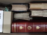 une boîte remplie de livres posés sur le sol