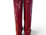 pair of red boots on a white surface with a white background