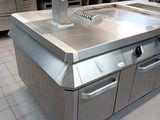 a large stainless steel kitchen island in the middle of a kitchen