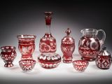 un ensemble de vases en verre rouge posés sur une surface blanche
