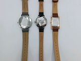 three different watches sitting on top of each other on a white surface