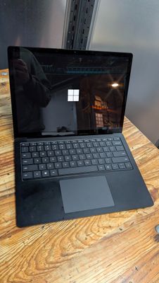 un ordinateur portable posé sur une table en bois