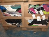 a cardboard box filled with lots of clothes on the floor
