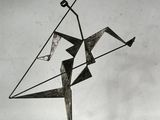 une photo d'une sculpture métallique représentant un homme tenant un cerf-volant