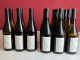six bouteilles de vin sont alignées sur une table