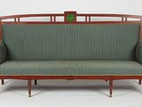 une image représentant un canapé vert avec une structure en bois et une assise rembourrée verte