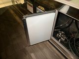 a small refrigerator that is open on the floor
