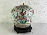 a vase that has a bird on it on a stand