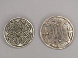 deux pièces d'argent ornées de motifs, placées l'une à côté de l'autre