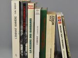 plusieurs livres sont empilés sur une surface grise